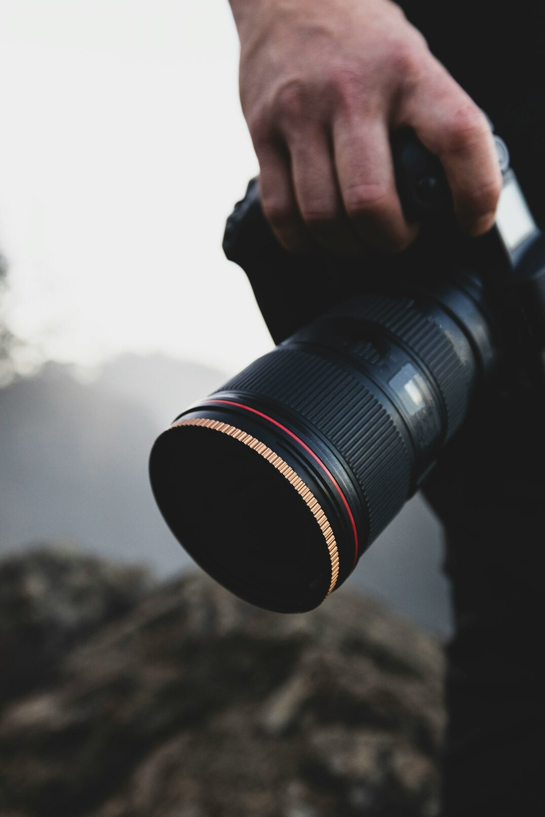 Professional photographer holding a camera with telephoto lens