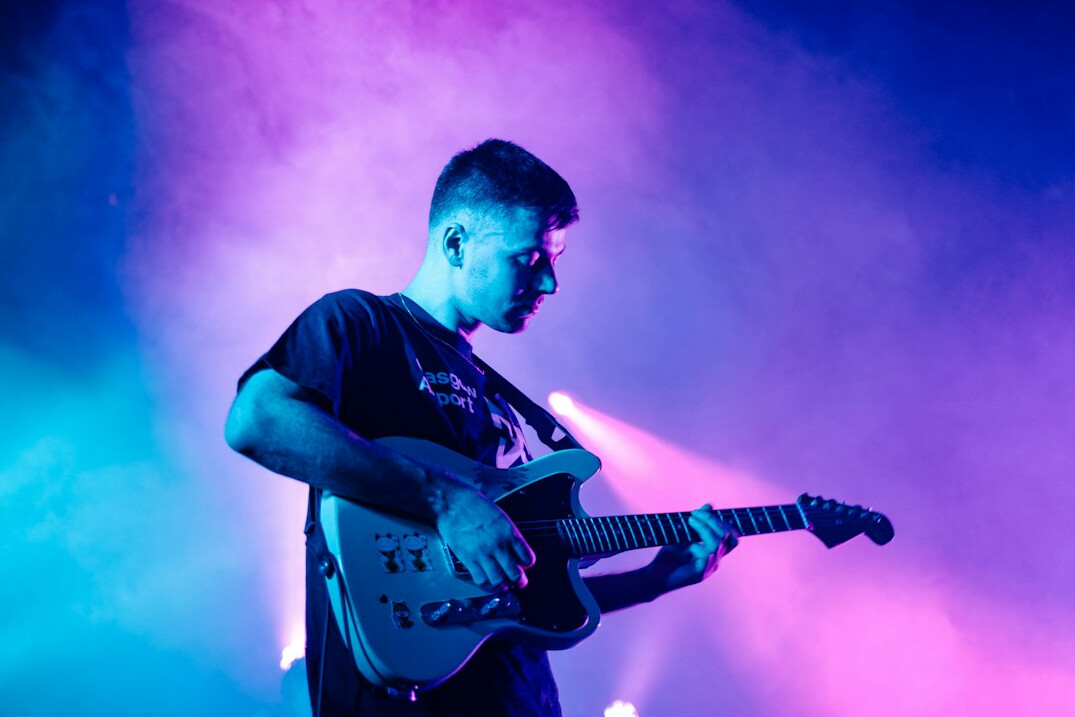 musician playing guitar on stage
